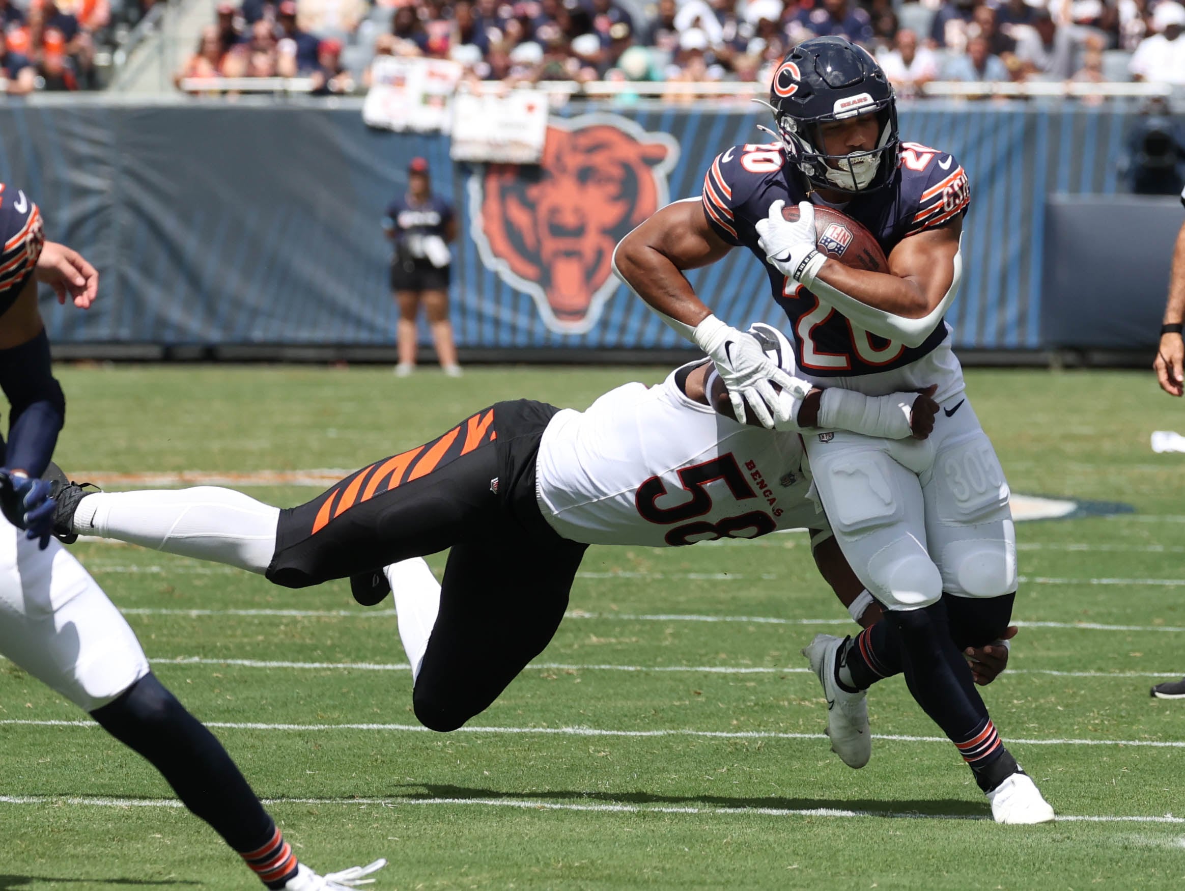 Chicago Bears running back Travis Homer tries to avoid Cincinnati Bengals defensive end Joseph Ossai during their game Saturday, Aug. 17, 2024, at Soldier Field in Chicago.