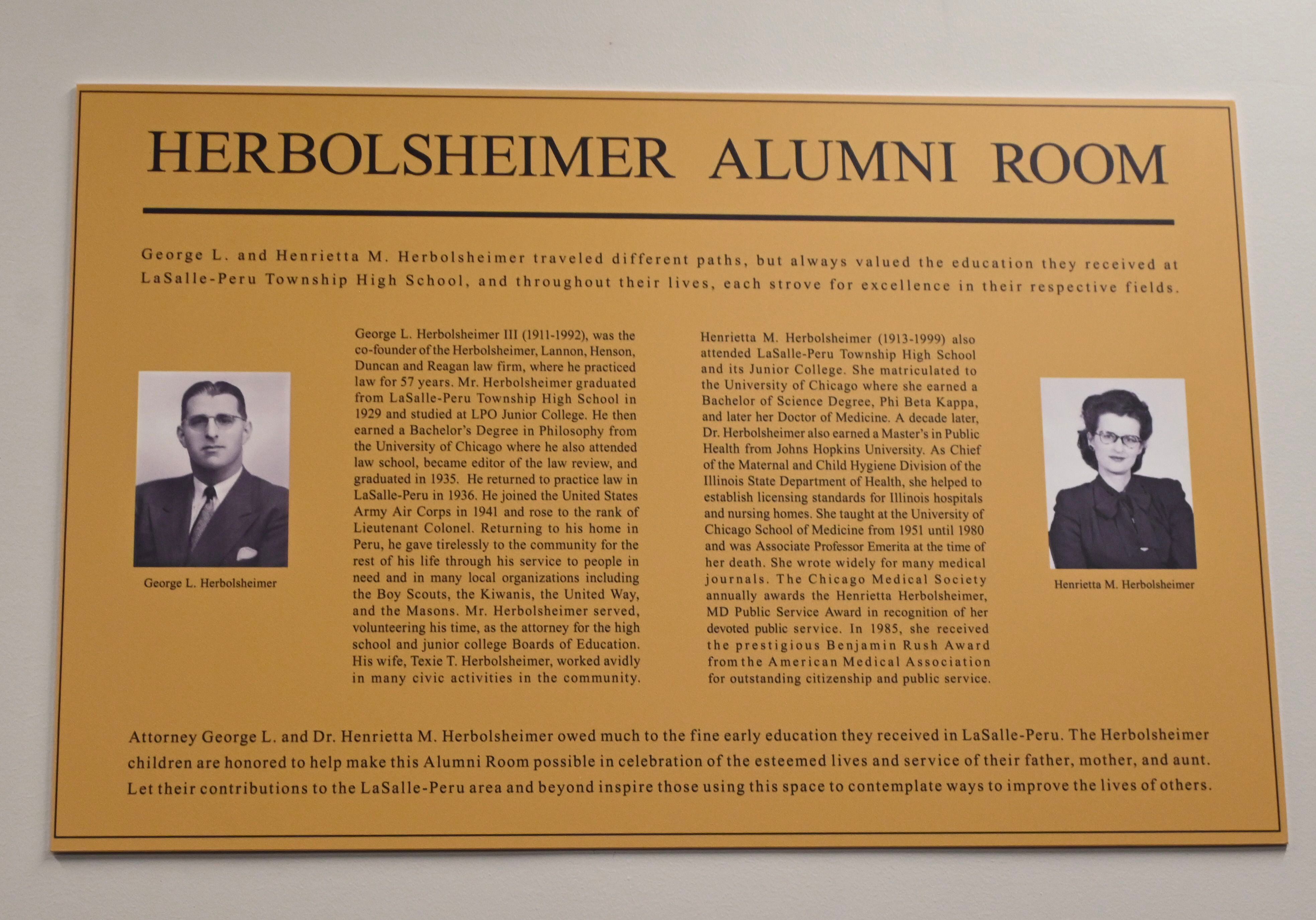 A plaque with George and Henrietta’s Herbolsheimer's photographs hangs in the center of the Herbolsheimer Alumni Room with a brief summary of each of their accomplishments.