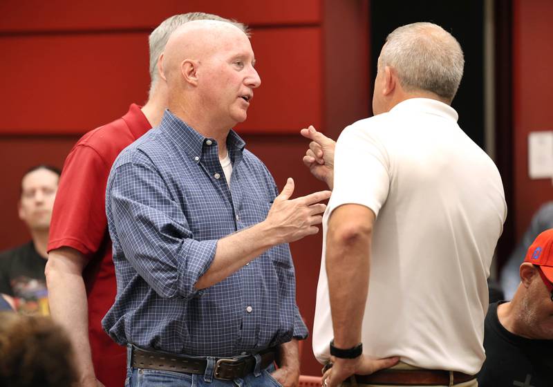 Dan Sears (front left) of D-N-J Properties, and owner of the building at 128 to 140 S. Second Street, along with his brother Joe Sears (back left) engage in a discussion with DeKalb Mayor Cohen Barnes (right) Monday, July 10, 2023, before the DeKalb City Council meeting. The city council has plans to consider acquiring and demolishing the 133-year-old building owned by Sears to provide space for additional downtown parking.