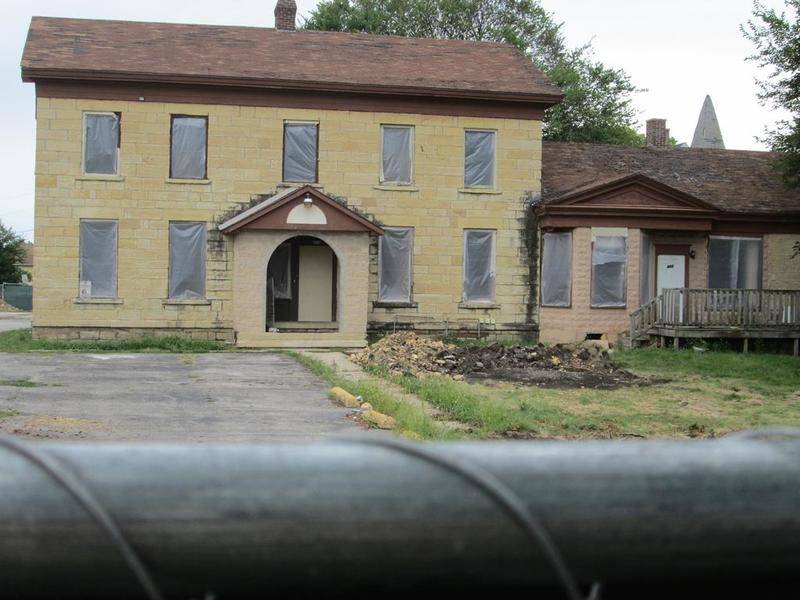 The 19th Century limestone house at 411 E. Jackson St. now is surrounded by construction fence and windows have been removed with plans to demolish it for a Thorntons gas station.