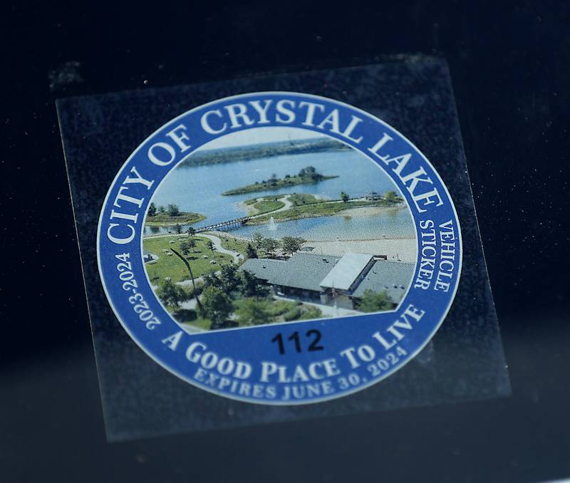 The new Crystal Lake vehicle permit sticker People in a car on Thursday, June 1, 2023. Crystal Lake is one of the few towns in McHenry County that require them.