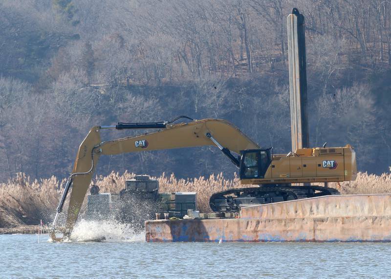 An escavator dredges near Delbridge Island about a mile east of the Starved Rock Lock and Dam on Tuesday, Feb. 13, 2024 near Starved Rock State Park. The Starved Rock Breakwater project is a habitat restoration effort designed to restore submerged aquatic vegetation in the Illinois River, Starved Rock Pool. It will increase the amount and quality of resting and feeding habitat for migratory waterfowl and improve spawning and nursery habitat for native fish.
Construction of the breakwater will involve placement of riprap along northern edge of the former Delbridge Island, adjacent to the navigation channel between River Mile 233 and 234. The breakwater structure will be approximately 6,100 feet long and constructed to a design elevation 461.85 feet, providing adequate protection to allow for submerged aquatic vegetation growth.
The estimated total cost of this project is between $5 and $10 million.