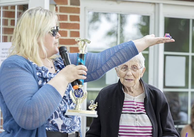 Vickie Smith holds aloft the winning car by resident Peg Nelson during the Franklin Grove Assisted Living car show Friday, June 23, 2023.