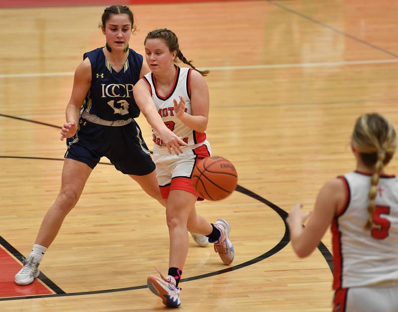 Timothy Christian's Mili Martens flips a no look pass to teammate Sami Drye (5) as IC Catholic's Analisa Raffaelli defends (left) during the Class 2A Timothy Christian Regional championship game on Feb. 17, 2023 at Timothy Christian High School in Elmhurst.