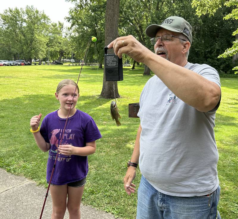 Kailyn Kellermann,  10, of Rock Falls, has the fish she caught weighed by Larry Deesing at the 18th annual Dick Brown Fishing Derby at Prophetstown State Park on Saturday, June 15, 2024.