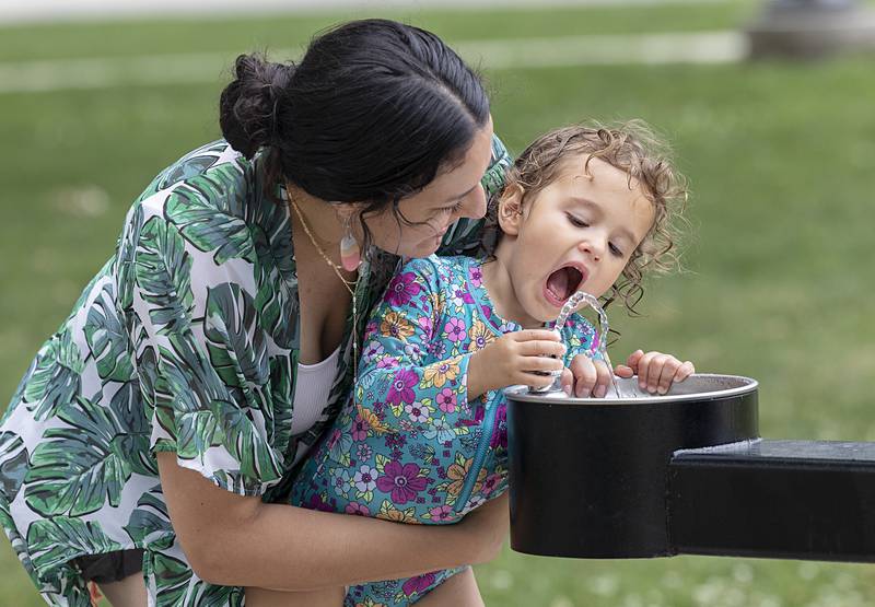 Mercedes Mancera helps her daughter Omri Aiza, 3, get a drink Saturday, June 22, 2024, during a Juneteenth celebration in Sterling.