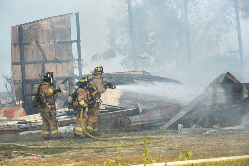 Firefighters douse burning debris at a Monday evening fire at a large machine shed at 7015 W. Judson Road, southeast of Polo. Several fire departments assisted the Polo Fire Department on the call. There were no injuries.