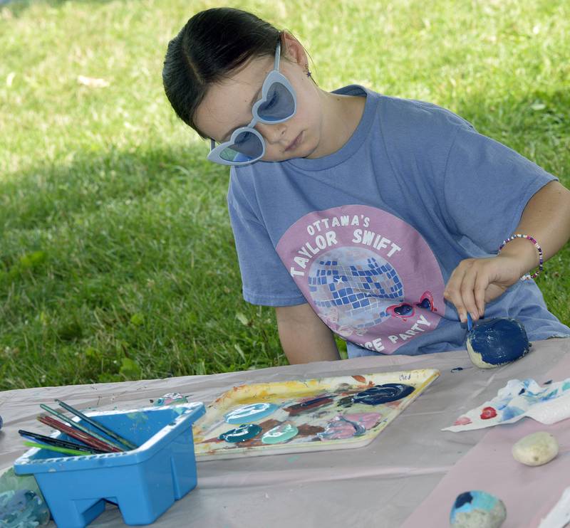 Nora VanDuzer decorates a rock Sunday during the Taylor Swift Dance Party in Ottawa. The event was part of Friendship Days.