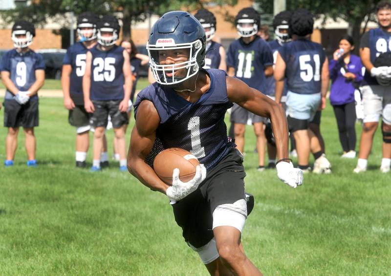Oswego's Jeremiah Cain takes a handoff and looks for an opening during football practice at Oswego High School on Monday, Aug 7, 2023.
