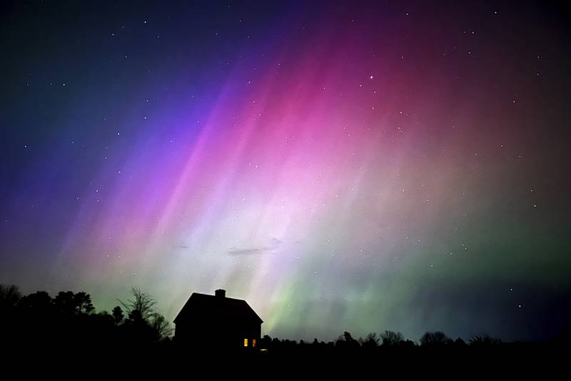 The northern lights flare in the sky over a farmhouse, late Friday, May 10, 2024, in Brunswick, Maine. (AP Photo/Robert F. Bukaty)