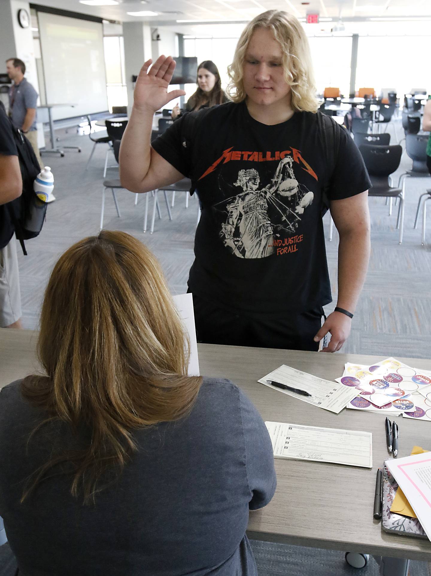 McHenry High School junior Jerry Poplawski swears that he eligible to register to vote to  English teacher Stacy Rockweiler, who is a deputy register, during a student voting registration event on Tuesday, Sept. 17, 2024, at the high school in McHenry.