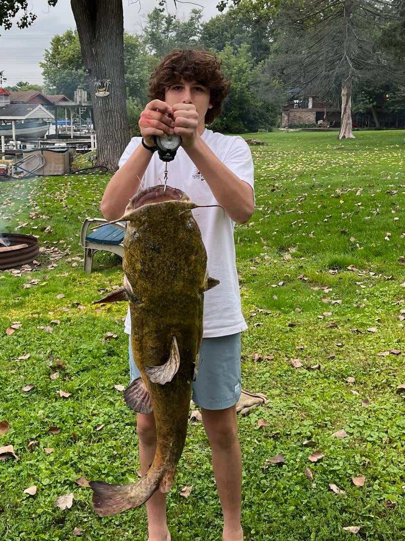 Kaden Norman, a Cary-Grove freshman, poses with his 43-pound flathead catfish, which he caught in the Fox River on Sunday.