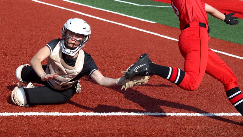 Huntley’s catcher Madison Rozanski, left, nabs the shoe of Barrington’s Maddie Van Run for an out at home plate in sectional final softball  action at Barrington Friday.