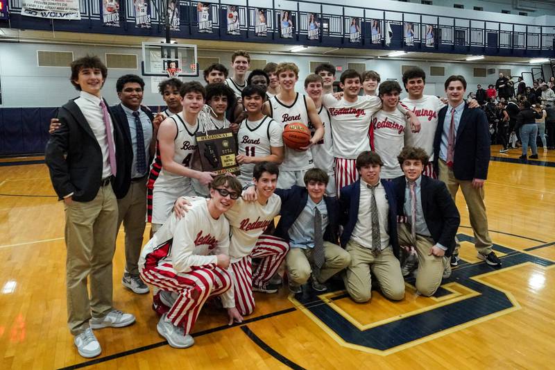 Benet players pose for photos with the regional 4A championship plaque after defeating Oswego East to win the Class 4A Oswego East regional final at Oswego East High School on Friday, Feb 23, 2024.