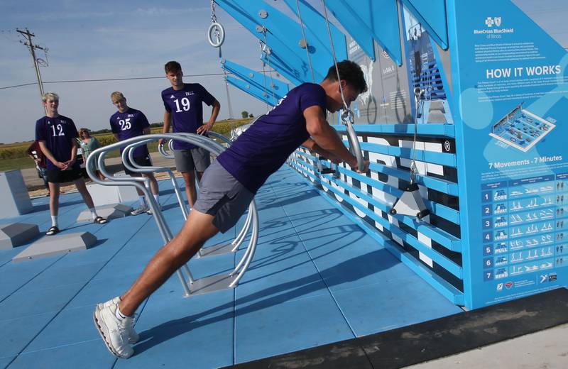 IVCC soccer player Rafael Romero of Mendota, demonstrates how to use a portion of the new outdoor fitness court as other players Noah Mzoughi, Nick Venjakob and Rutger Noordegraff watch on Wednesday, Sept. 18, 2024 at Rotary Park in La Salle.