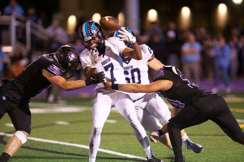 Downers Grove North's Joe Edwards (8) and Jake Gregorio causes a fumble by Downers Grove South's Keegan Garland on Friday Sept. 6,2024 in Downers Grove.