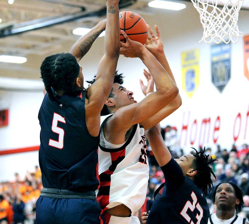 Bolingbrook's JR Pettigrew takes a tough shot between West Aurora defenders Terrence Smith (5) and Evan Hackney (23) during a class 4A regional championship basketball game at Yorkville High School on Friday, Feb. 23, 2024.