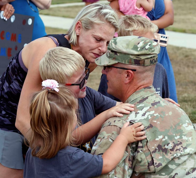 Staff Sgt. Eric Nowinski of Spring Grove is reunited with his family, including his wife, Michelle, and three children, Logan, 7; Teddy, 5; Isabelle, 3, Tuesday at the U.S. Army Reserve Center in Arlington Heights.