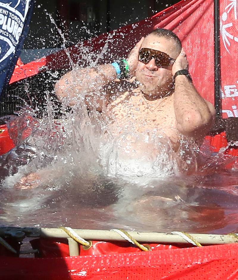 A shirtless participant jumps into the water on a cold and windy Saturday, Feb 17, 2024, during the Huskie Stadium Polar Plunge at Northern Illinois University in DeKalb. The Polar Plunge is the signature fundraiser for Special Olympics Illinois.