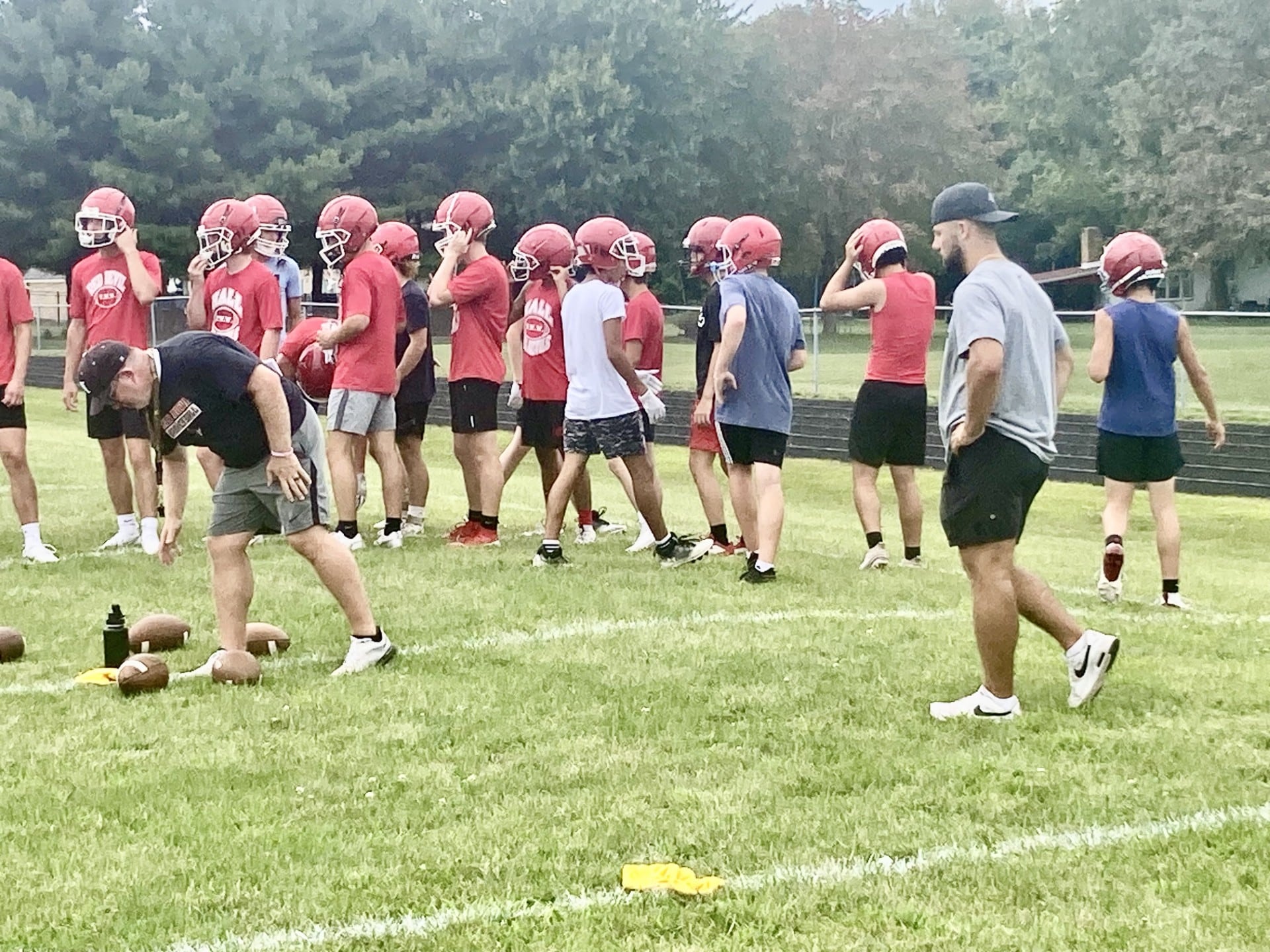 Hall alum James Mautino (right) helps out during the Red Devils' first practice of the season on Monday afternoon. He is on the call list for the Chicago Bears and Pittsburgh Steelers to be added to their. practice squads in the event of injuries.