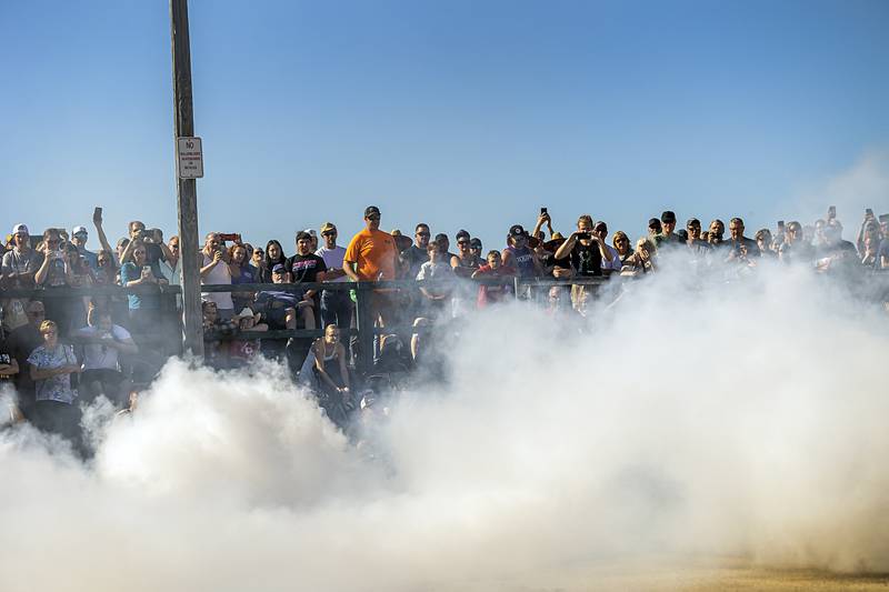 Plumes of burning rubber smoke fill the air as visitors watch the high-powered vehicles tear down the strip Monday, June 10, 2024 in Rock Falls.