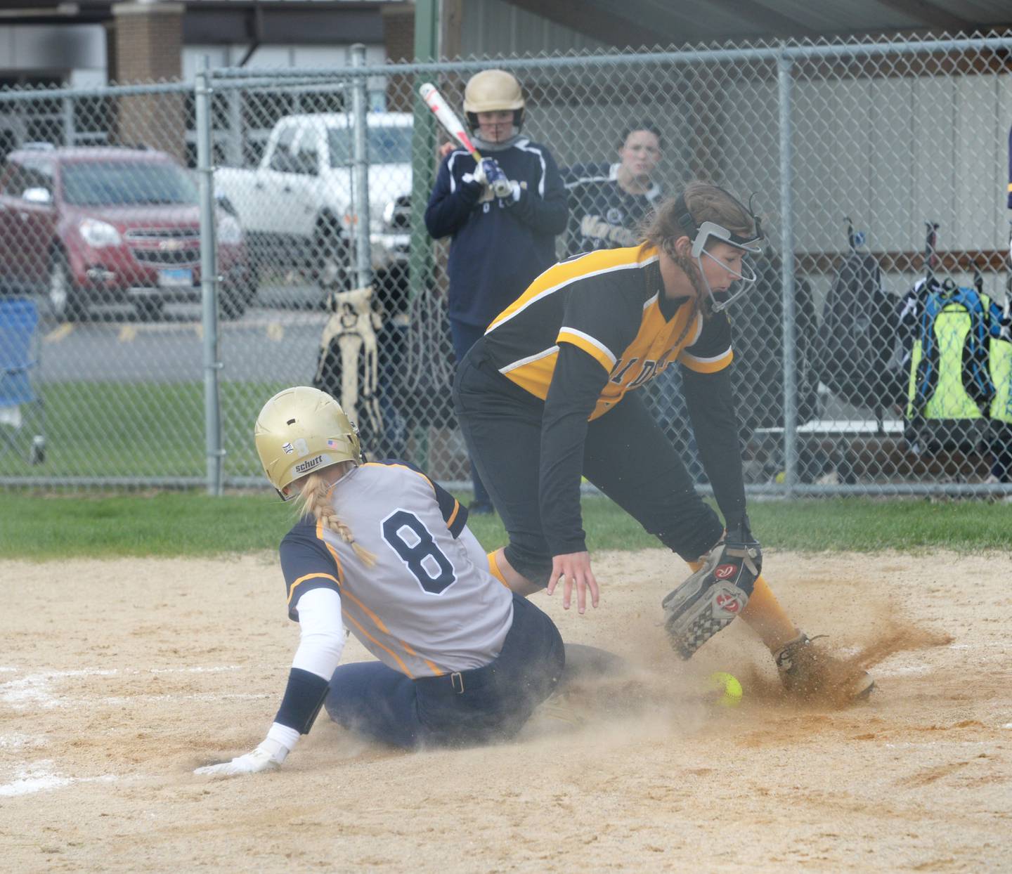 Polo's Sydnei Rahn slides safely into home as the ball evades AFC's Alexis Schwarz during a Tuesday, April 25 game in Ashton.