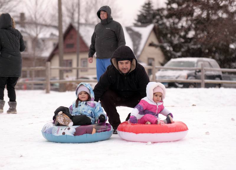 Saul Alvarez of Brookfield assists his daughters (left) Liliana and Esmeralda down the Memorial Park hill in Lagrange Park Saturday, Jan 13, 2024.