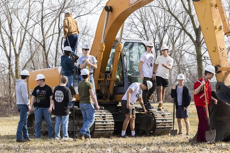 WACC students hang out on an excavator Tuesday, Feb. 27, 2024 during a ground breaking in Rock Falls. Building trade students will be part of the building of the Rock Falls structures.