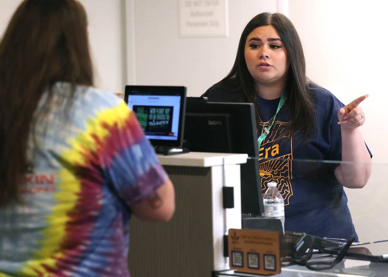 Alyssa Martinez, (right) a budtender at nuEra cannabis dispensary, talks to customer Emma Ingram, from DeKalb, Thursday, May 23, 2024, about some of the products offered at the new business in DeKalb. Thursday was opening day for the dispensary which is located at 818 West Lincoln Highway, in the Junction Shopping Center.