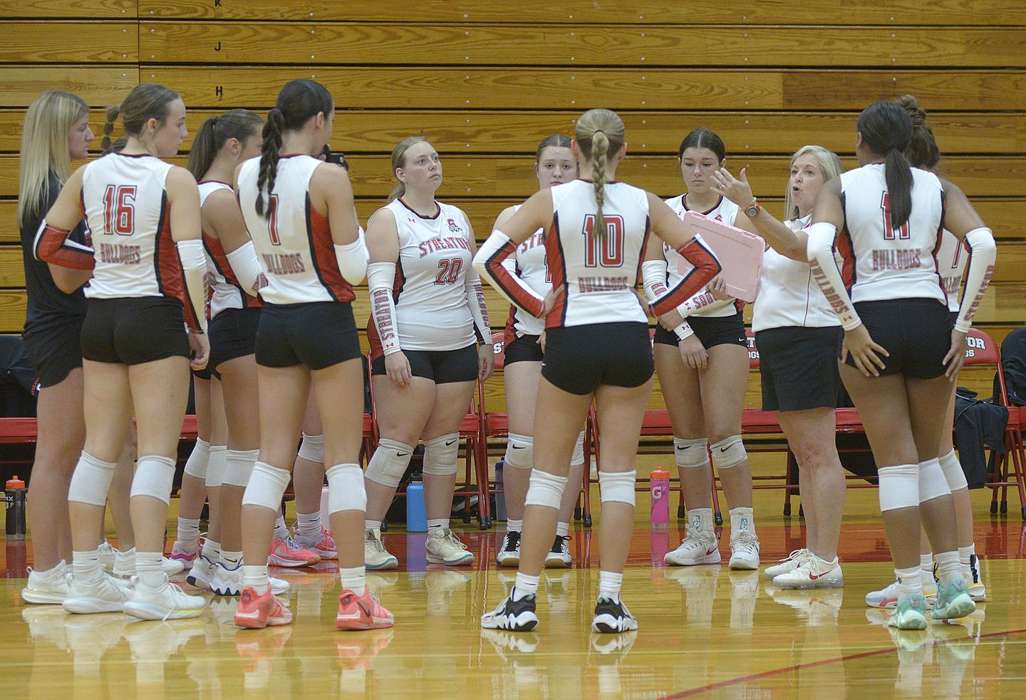 Lady Bulldogs coach Julie Gabehart regroups the team during a timeout after losing their lead to Pontiac in the first set Wednesday at Streator.