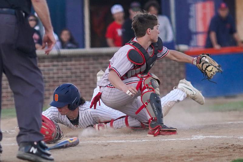 Yorkville's Miles Nehring (18) beats the throw to home for a score against Yorkville during a baseball game at Oswego High School on Monday, April 29, 2024.