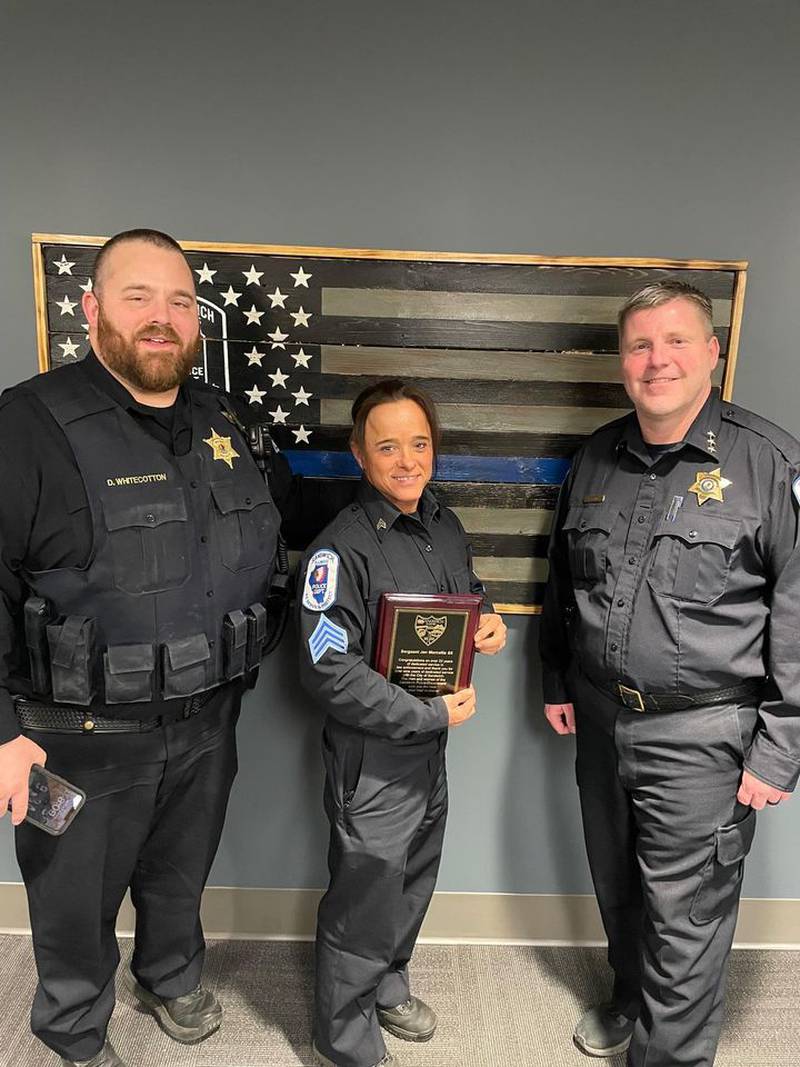 Sandwich Police Department Sergeant Dan Whitecotton, left, and Sandwich Police Chief Kevin Senne, right, present recently retired Sandwich Police Department patrol and detective sergeant Jennifer Marcellis, center, with her retirement plaque.