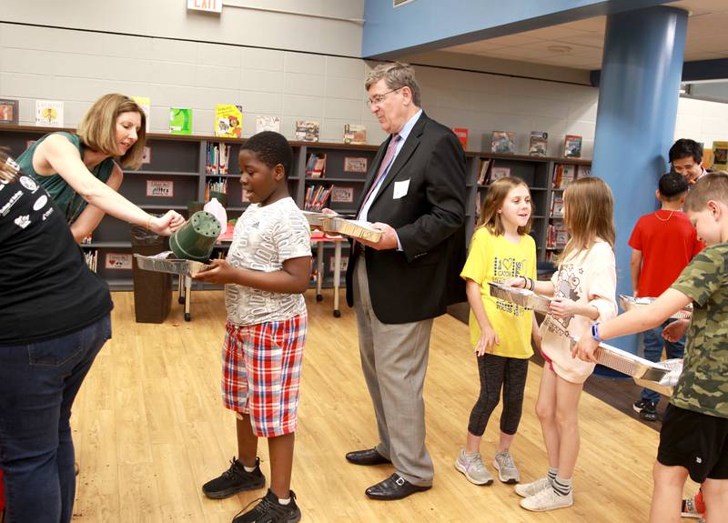 Wheaton Mayor Phil Suess waits with Washington Elementary School fourth graders as teacher Krista Lipnisky fills pans of potting soil for her students to plant cherry tomatoes at the Wheaton school on Tuesday, May 7, 2024. The plantings are part of the DuPage County Farm Bureau’s Grow Your Own Food project, which plans to include 4,000 fourth graders throughout DuPage County this spring.