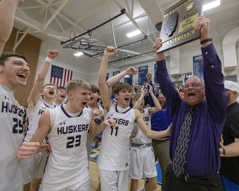 Serena High School assistant coach Randy Goodbred celebrates the IHSA boys basketball class 1A regional championship with members of the Huskers after their victory over Marquette on February 23, 2024.