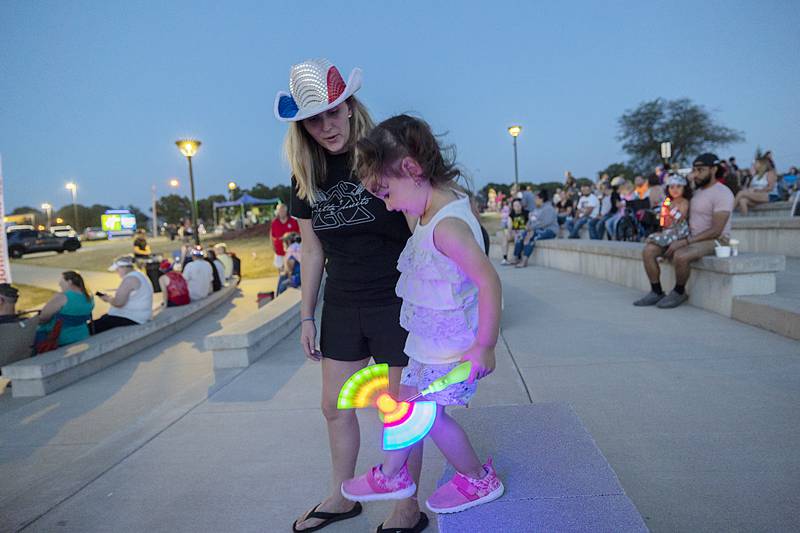 Carly Moore helps daughter Ella, 2, down from the RB&W Park theater seats Friday, June 30, 2023 before the start of the fireworks.