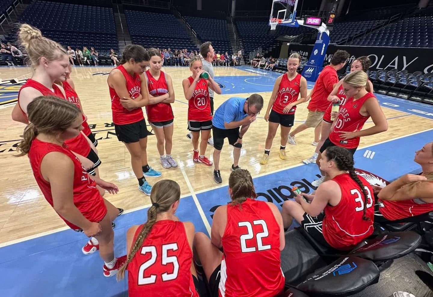 Ottawa girls basketball coach Brent Moore (center) talks things over with his Pirates squad during their summer scrimmage against Geneseo in early June at Wintrust Arena in Chicago, home of the WNBA's Chicago Sky.