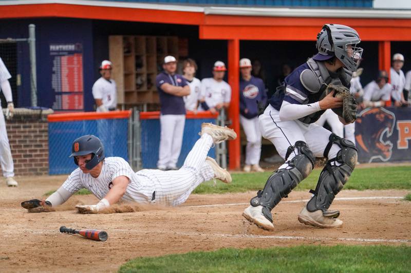 Oswego’s Dylan King (20) slides in for a score against Oswego East during a baseball game at Oswego High School on Monday, May 13, 2024.