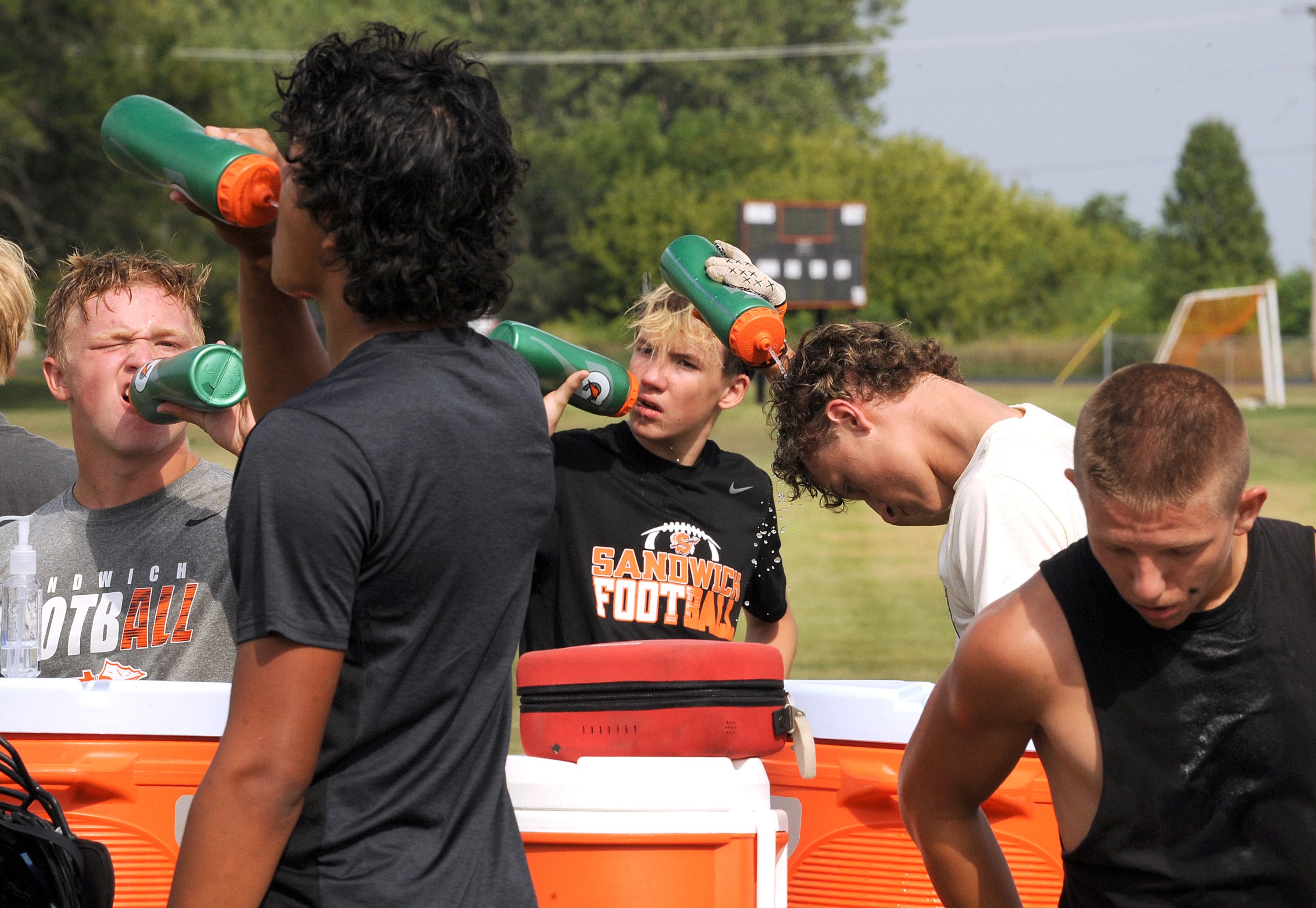 Sandwich football player take a water break during the first day of football practice at Sandwich High School on Monday, Aug. 12, 2024.