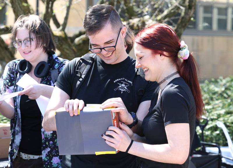 Alex Warren, a Northern Illinois University junior from Hinckley, and Emily Kapala, a senior from Buffalo Grove, build an eclipse viewer Monday, April 8, 2024, at the NIU Solar Eclipse Viewing Party behind Davis Hall in DeKalb. Attendees were treated to perfect weather to watch the rare celestial event.