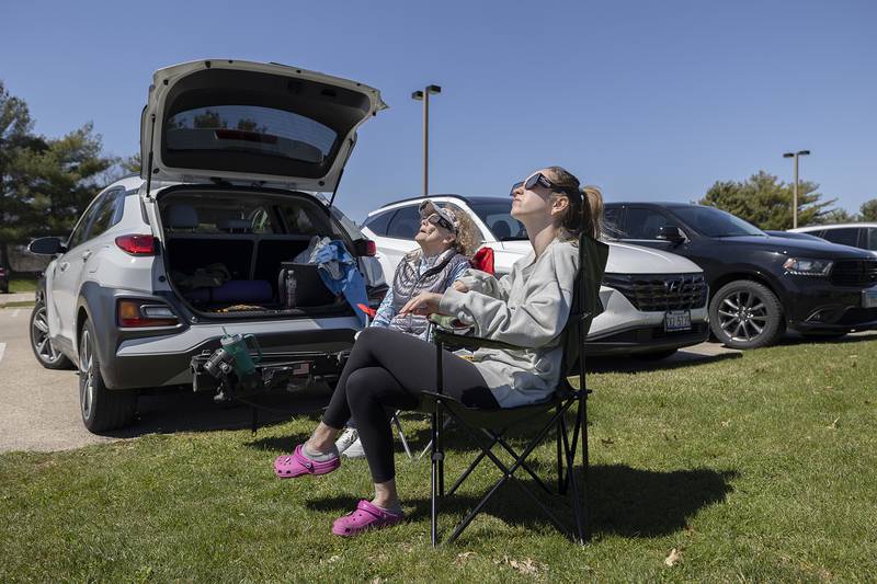 Mary Ristow and granddaughter Hailey Donndelinger of Madison, Wisconsin, check out the emerging eclipse Monday, April 8, 2024. The two drove into Dixon for a better viewing of the celestial phenomenon and found their way to Sauk Valley Community College.