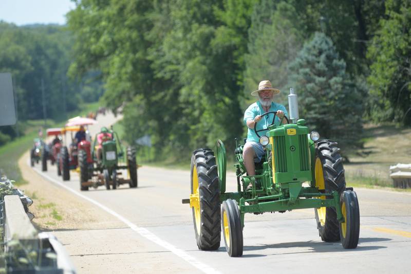 Tom Brown of Oregon a string of tractors north on Daysville Road in his 1950 John Deere 420 during the Living History Antique Equipment Association's tractor drive on Saturday. About 40 tractors took part in the ride that started at the association's show grounds in Franklin Grove and traveled to Oregon and back.