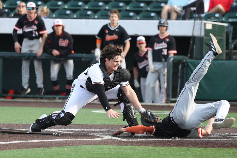 Joliet Catholic’s Zach Pamatto prevents the tying run in the bottom of the 7th by tagging out Minooka’s Hayden Host at the plate in the WJOL tournament championship on Saturday, March 30, 2024 in Joliet.