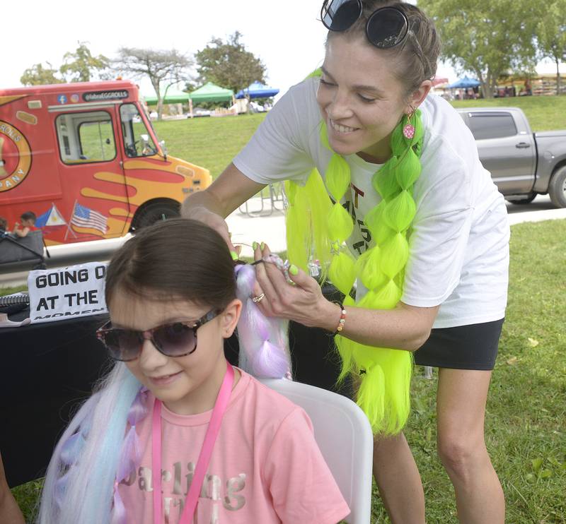 Abigail Milton has a colorful hair extension applied Sunday during the Taylor Swift Dance Party in Ottawa. The event was part of Friendship Days.