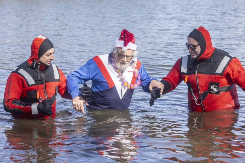 Rescue divers help a participant into and out of the water during the 2024 Special Olympics Polar Plunge at Lake Mendota on February 24, 2024.