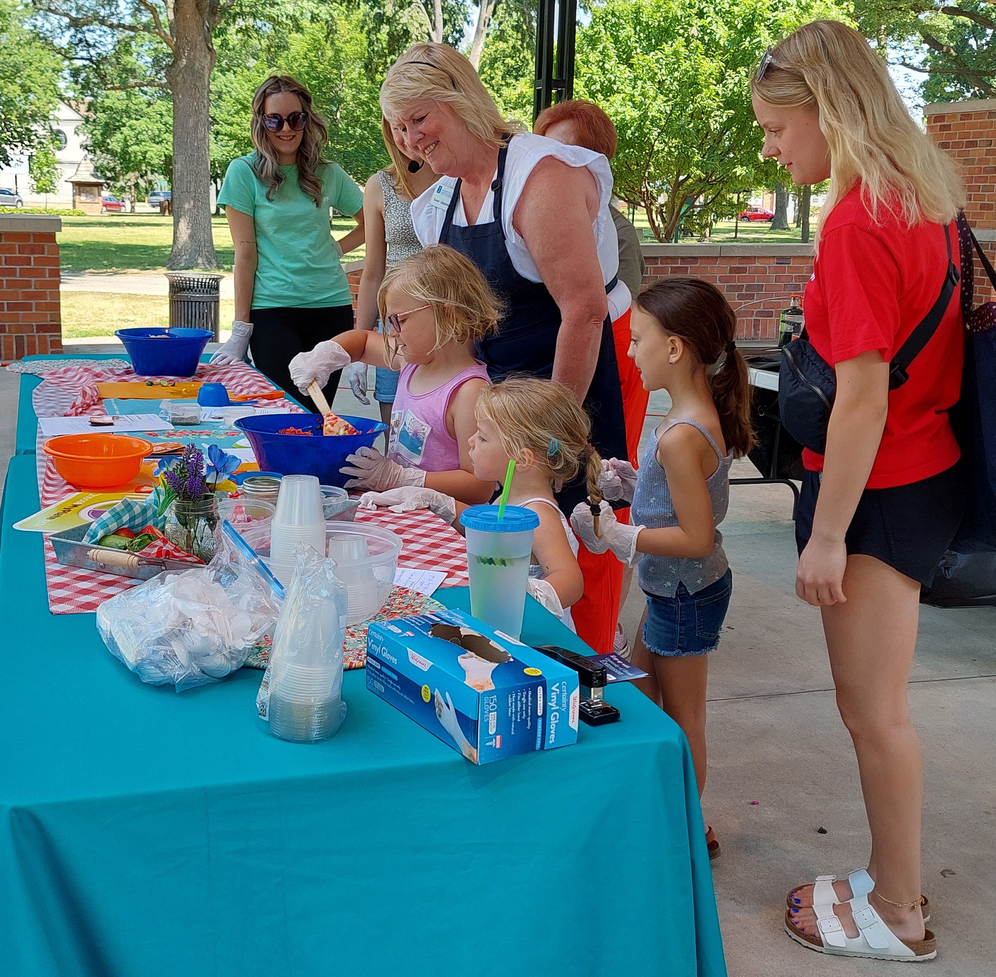 Riley Jansen helps stir the salsa during a University of Illinois Extension cooking demonstration on the Plumb Pavilion stage Saturday, June 10, 2023, as part of Live Well Streator's Family Health and Fitness Day. Her sister Molly also assisted.