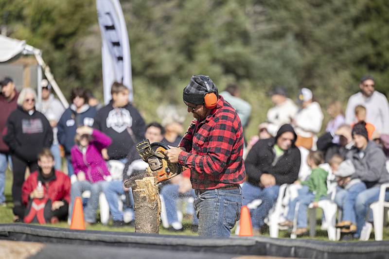 Lumberjack show emcee Jamie Fischer carves a little chair as a prize for a visitor to the show Saturday, Oct. 7, 2023.