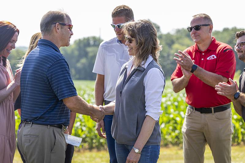 Duane Long shakes hands with Kiersten Sheets after the solar company donated $20,000 to the district Friday, June 21, 2024.