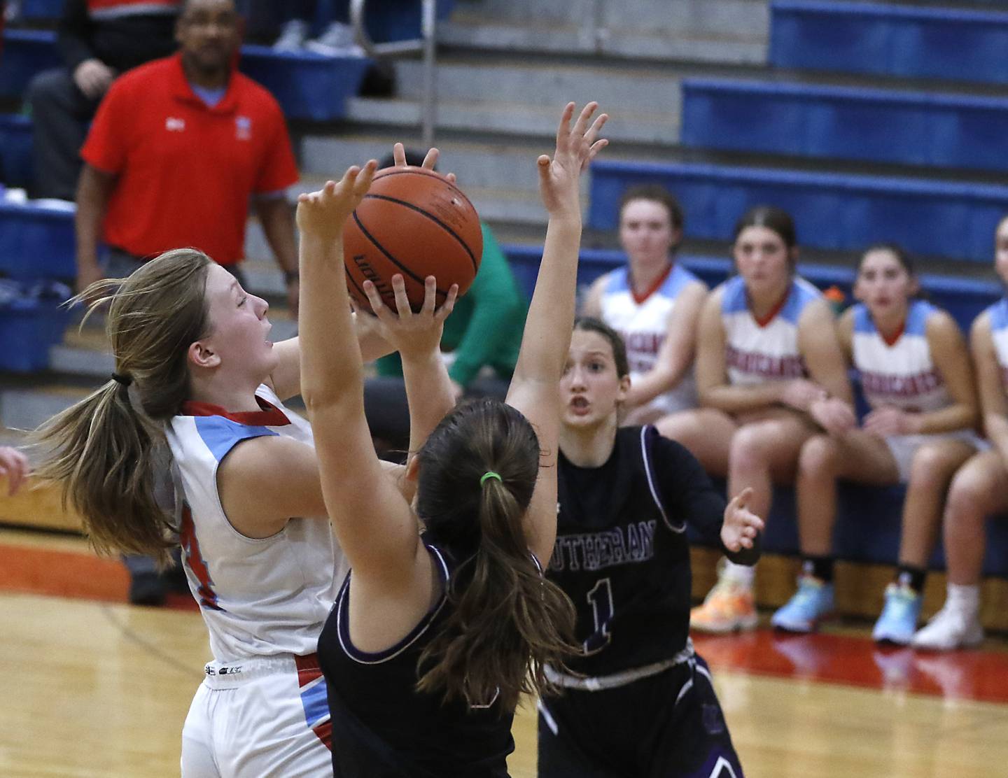 Marian Central's Abbey Miner shoots the game winning basket between Rockford Lutheran's Addie Richard and Soraya Parker during a non-conference girls basketball game Monday, Dec. 12, 2022, between Marian Central and Rockford Lutheran at Marian Central Catholic High School, in Woodstock.