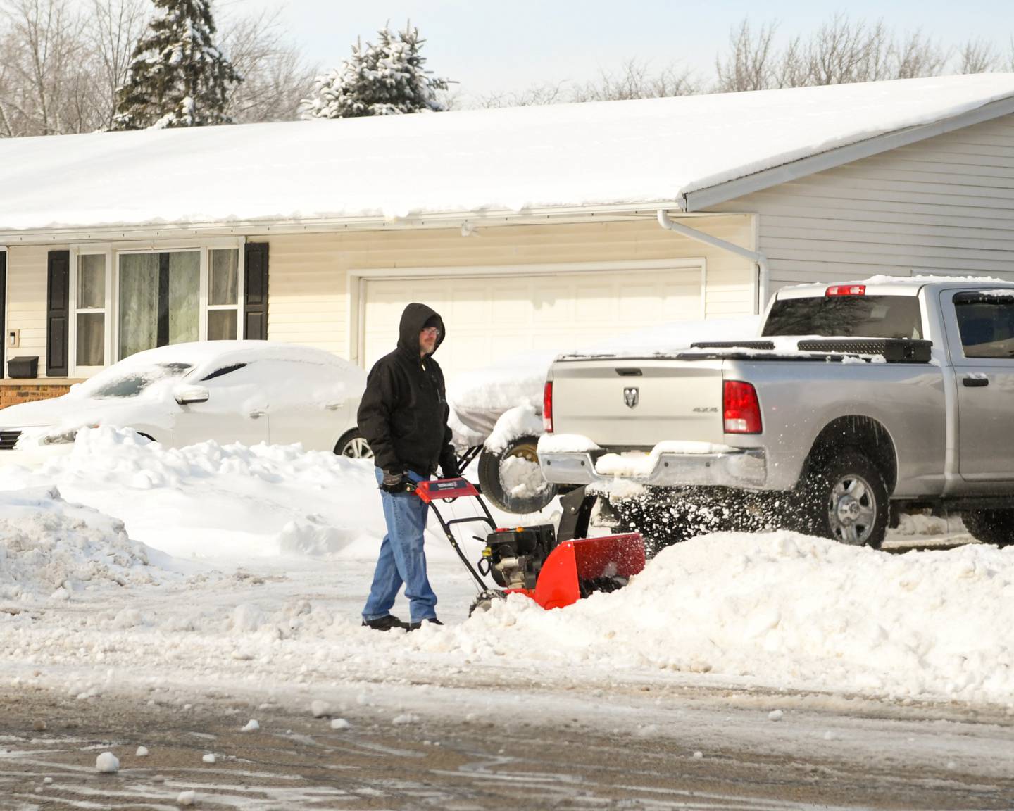 Jamie Gillies Snow blows a driveway in Sycamore Saturday morning on Saturday Jan. 13, 2024.