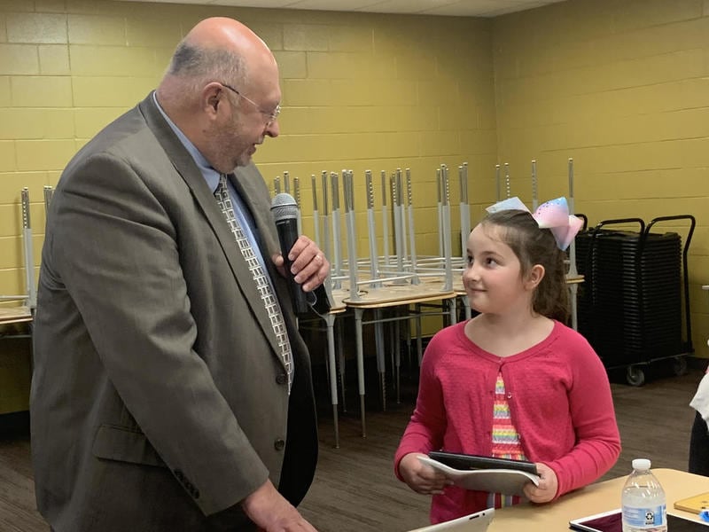 Lainey Person, a young author who represented the second through third grade student division from Sycamore School District tells Sycamore school board president Jim Dombek about her story, "No More First Ladies: A Story About Why Women Should be President," Tuesday, March 10, 2020, at Sycamore School District's school board meeting.